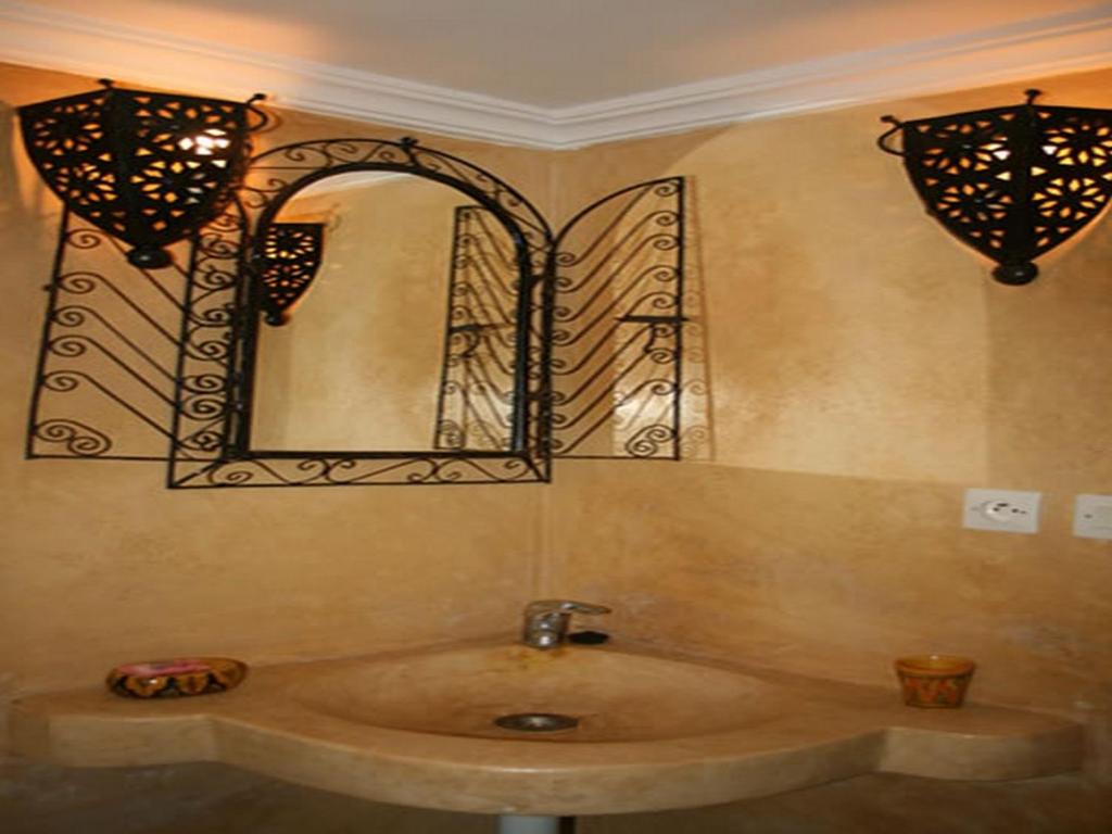 une salle de bain avec un lavabo et un miroir au mur dans l'établissement Riad Etoile D'essaouira, à Essaouira