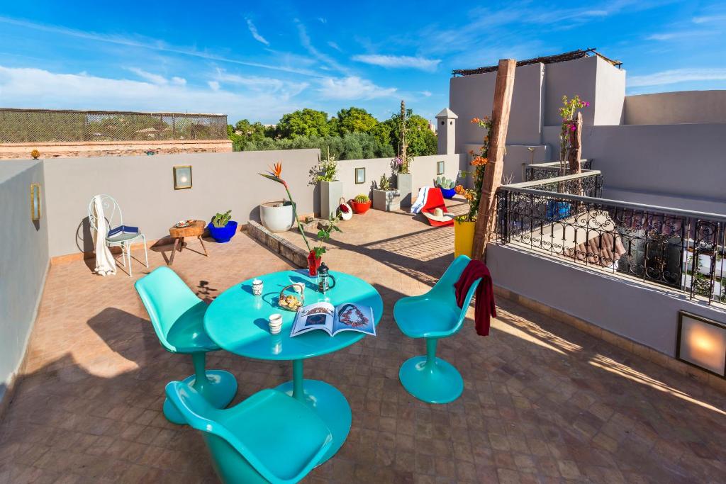 un patio avec une table et des chaises sur un toit dans l'établissement Riad Lumière, à Marrakech