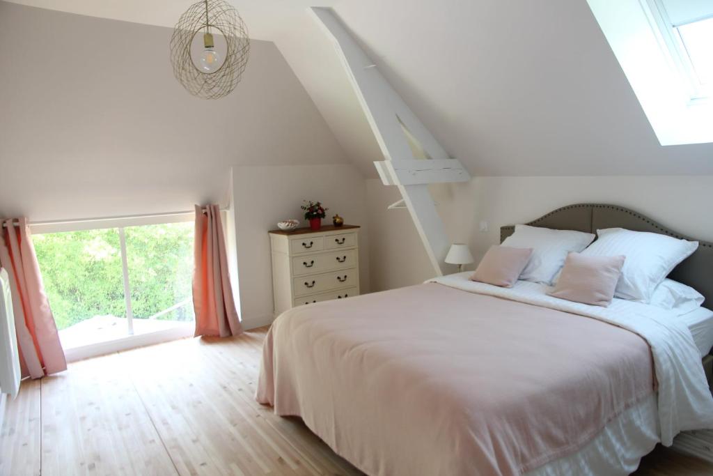 une chambre avec un lit blanc et une fenêtre dans l'établissement Gite L'Hermine, à Azay-le-Rideau
