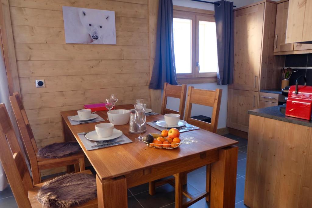 - une table en bois avec un bol de fruits dans l'établissement Appartement Soleil Blanc Résidence Lodge des neiges, à Tignes