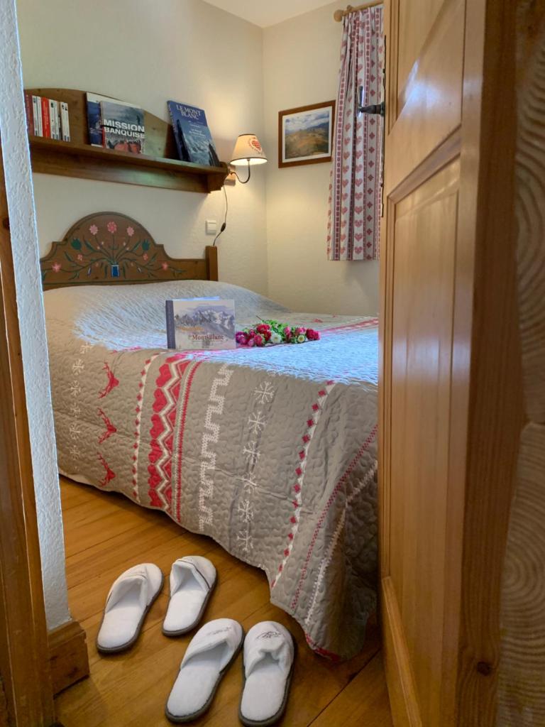 - une paire de chaussons blancs à l'étage, à côté d'un lit dans l'établissement La clé des montagnes, aux Houches 7 autres photos