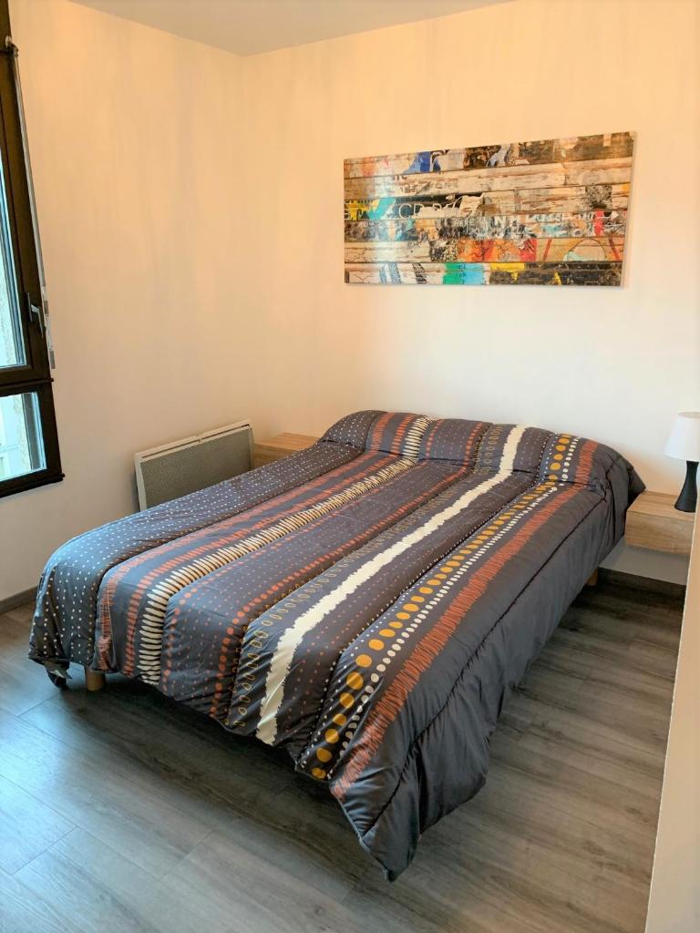 - une chambre avec un lit et une couverture colorée dans l'établissement Appartement 4p luchon cures & ski Soda, à Luchon