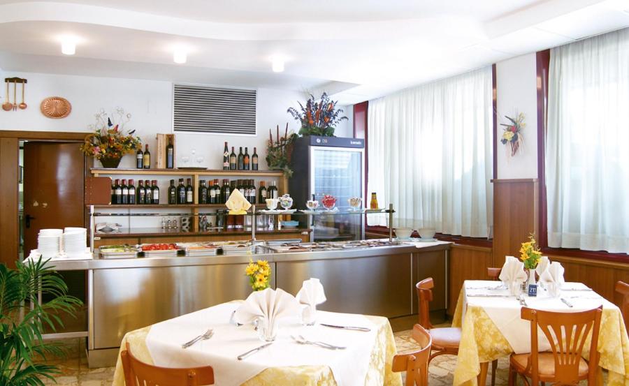 un restaurant avec deux tables et un comptoir dans l'établissement Hotel Nelson, à Lido di Jesolo 9 autres photos