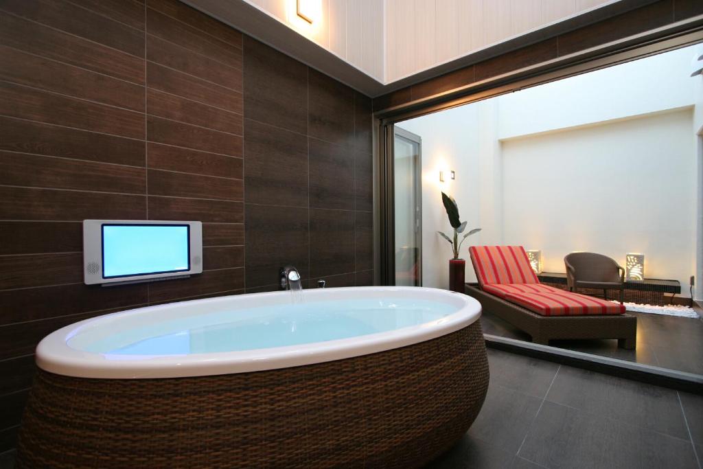 Cette chambre comprend une salle de bains pourvue d'une baignoire et une télévision. dans l'établissement HOTEL W-PREMIUM -W GROUP HOTELS and RESORTS-, à Koshigaya