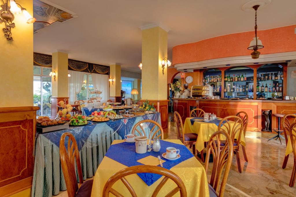 un restaurant avec des tables et des chaises et un bar dans l'établissement Hotel Napoleon, à Lido di Jesolo