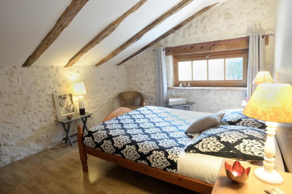 une chambre avec un lit et une table avec une lampe dans l'établissement Les Gîtes de La Treille, à Montagrier 37 autres photos