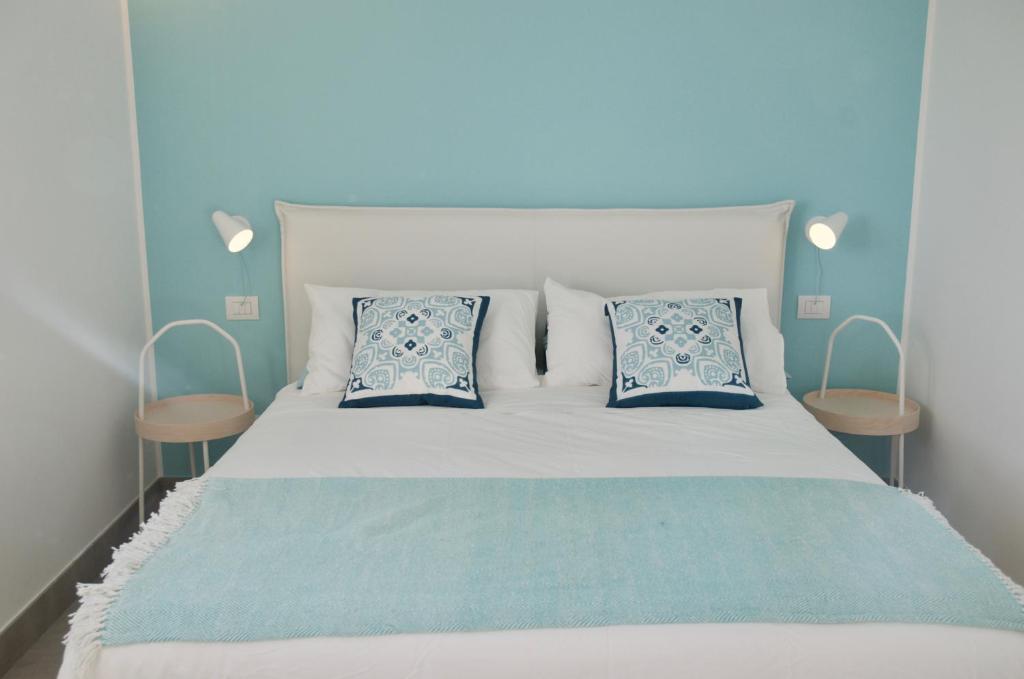 - un lit avec 2 oreillers bleus et blancs dans l'établissement villa MAMA Marina di ragusa, à Marina di Ragusa 21 autres photos