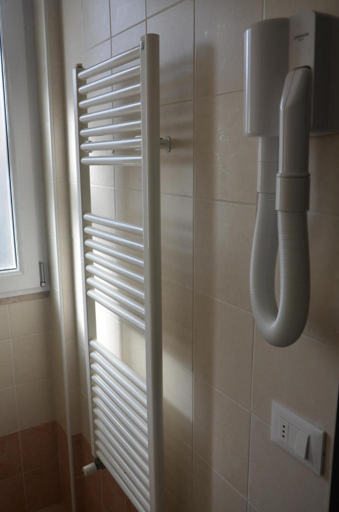 La salle de bains est pourvue d'une porte de douche en verre et d'un téléphone. dans l'établissement Residence Della Vista, à Rimini