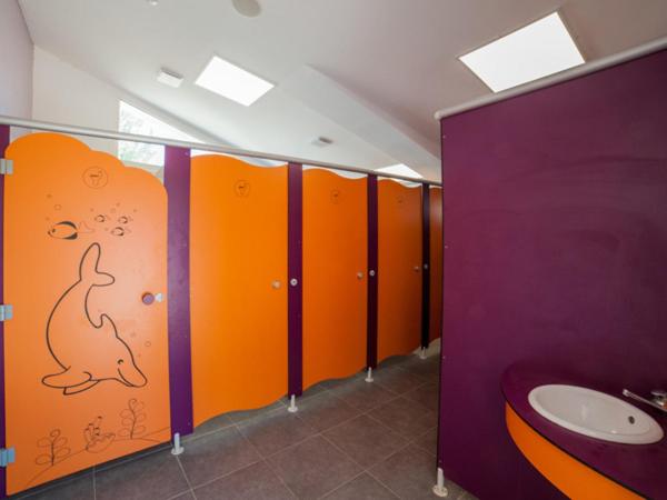 - une salle de bains avec des stalles orange et pourpre avec un chien sur le mur dans l'établissement Oh! Campings - Le Clos du Rhône, à Saintes-Maries-de-la-Mer