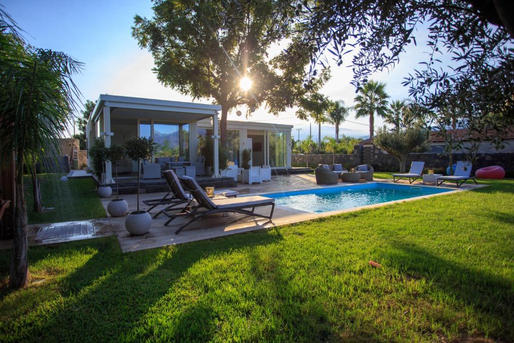 une cour arrière avec une piscine et une maison dans l'établissement T Villa, à Calatabiano