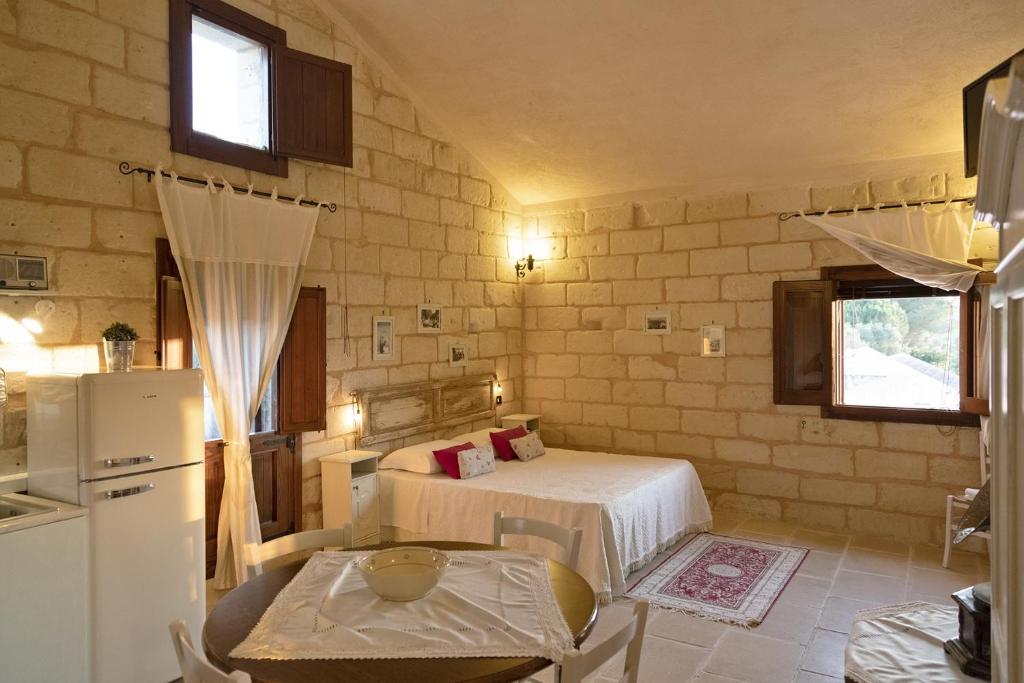 Cette petite chambre comprend un lit et un réfrigérateur. dans l'établissement Masseria Salentina Costarella, à Borgagne