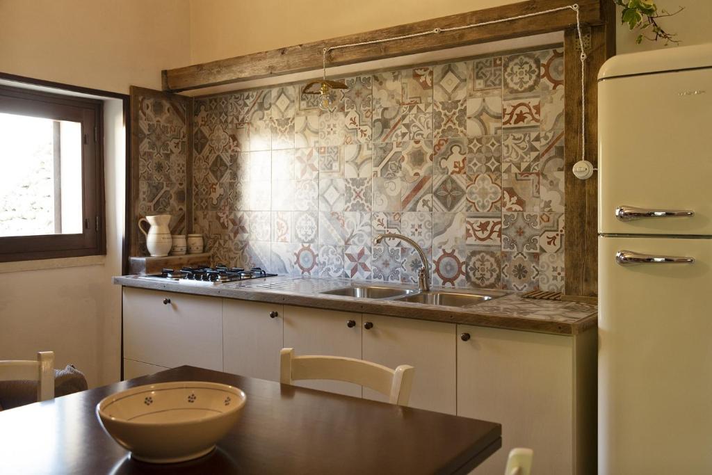 une cuisine avec un évier et un réfrigérateur dans l'établissement Masseria Salentina Costarella, à Borgagne