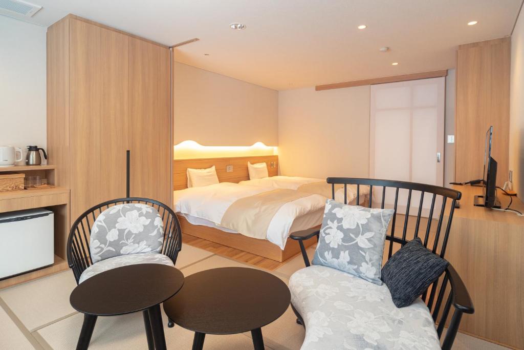 une chambre avec un lit, une table et des chaises dans l'établissement Kyukamura Myoko, à Myōkō 29 autres photos