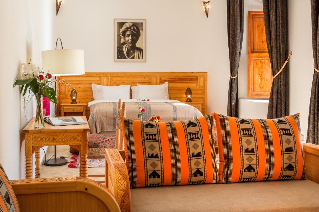 Cette chambre d'hôtel comprend un lit et une table avec un siège social. dans l'établissement Riad Sougtani, à Marrakech