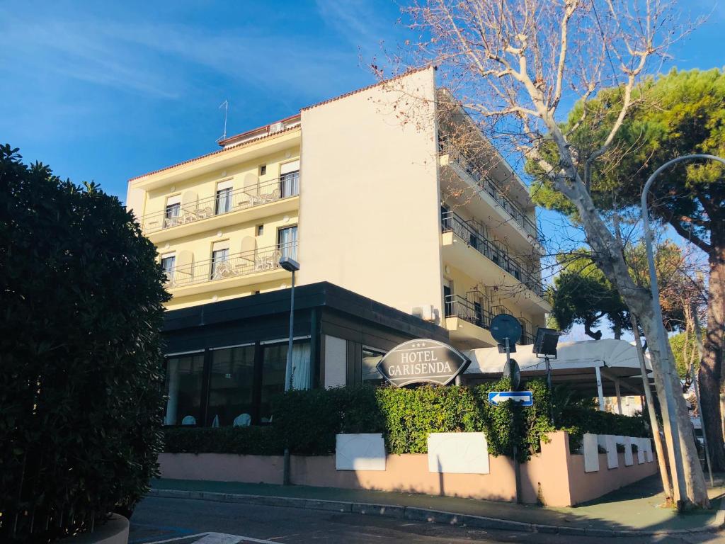 un grand bâtiment blanc au bord d'une rue dans l'établissement Hotel Garisenda B&B - in Centro a Riccione -, à Riccione
