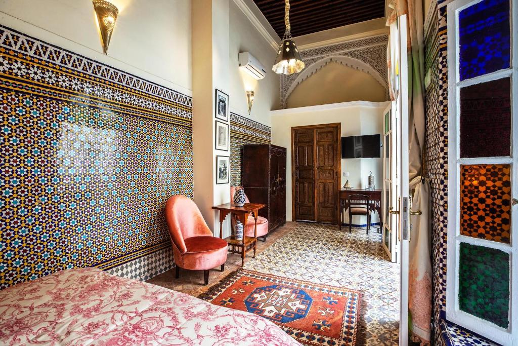 une chambre avec un lit et une chaise dans une pièce dans l'établissement Dar Kika Salam By DKS, à Rabat