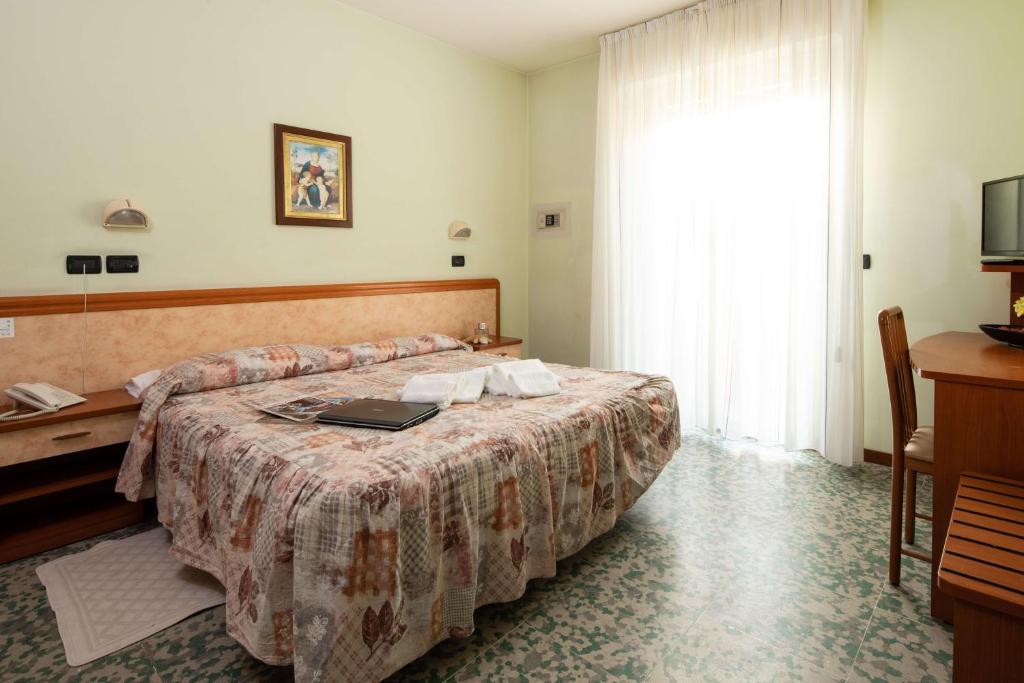 une chambre d'hôtel avec un lit avec un ordinateur portable dessus dans l'établissement EURO b&b, à Cattolica