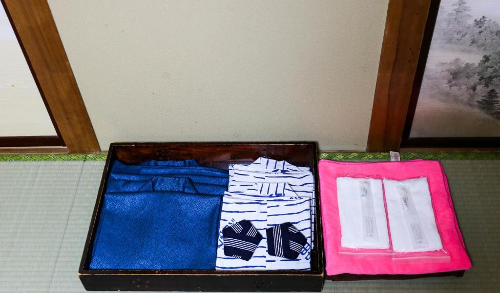 une valise remplie de vêtements assis sur une table dans l'établissement Rakki OnsenRyokan 楽奇温泉旅館, à Yamanouchi