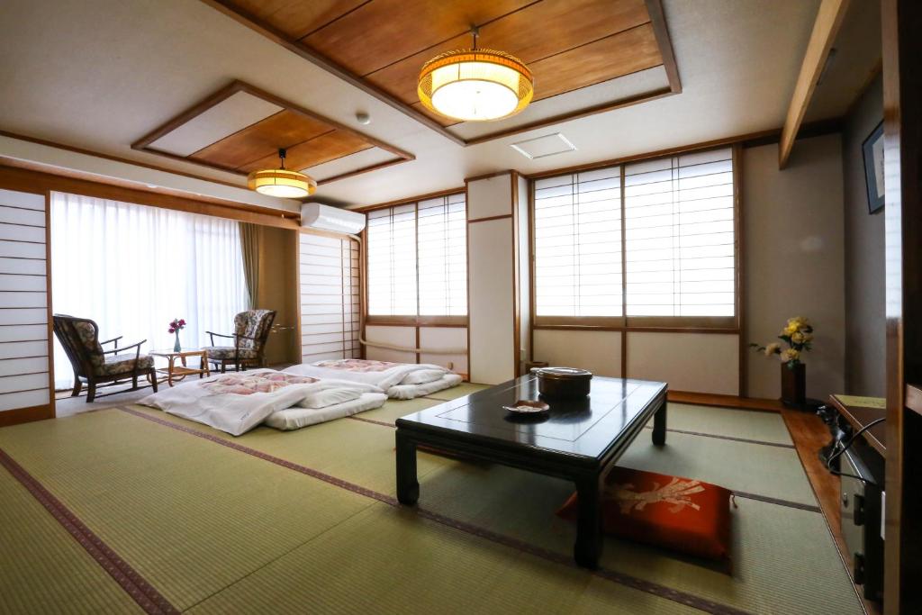 un salon avec un lit et une table dans l'établissement Rakki OnsenRyokan 楽奇温泉旅館, à Yamanouchi