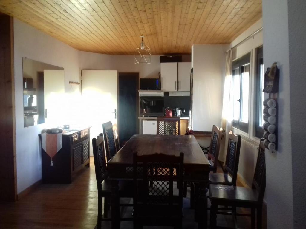 une cuisine et une salle à manger avec une table et des chaises dans l'établissement Appartement en loft 50m2 dans maison avec chambre en mezzanine et canapes lits dans salon, à Saint-Pierre-de-Chartreuse