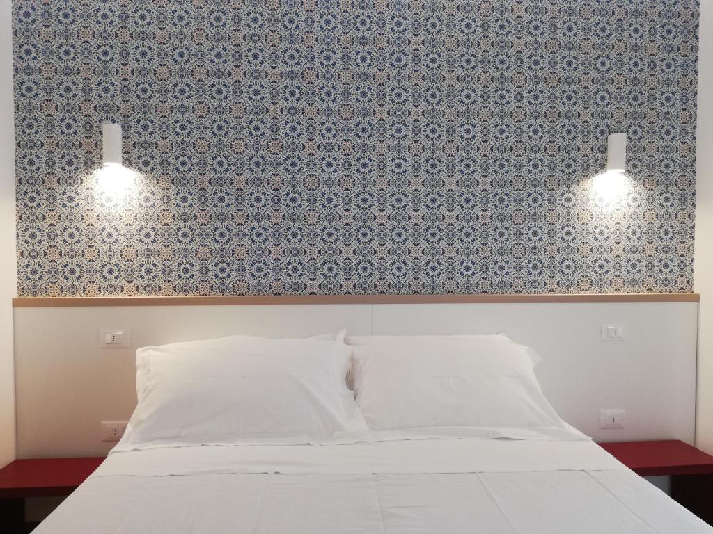 - une chambre avec un lit blanc et deux lumières dans l'établissement Milan Residence, à Rosolina Mare