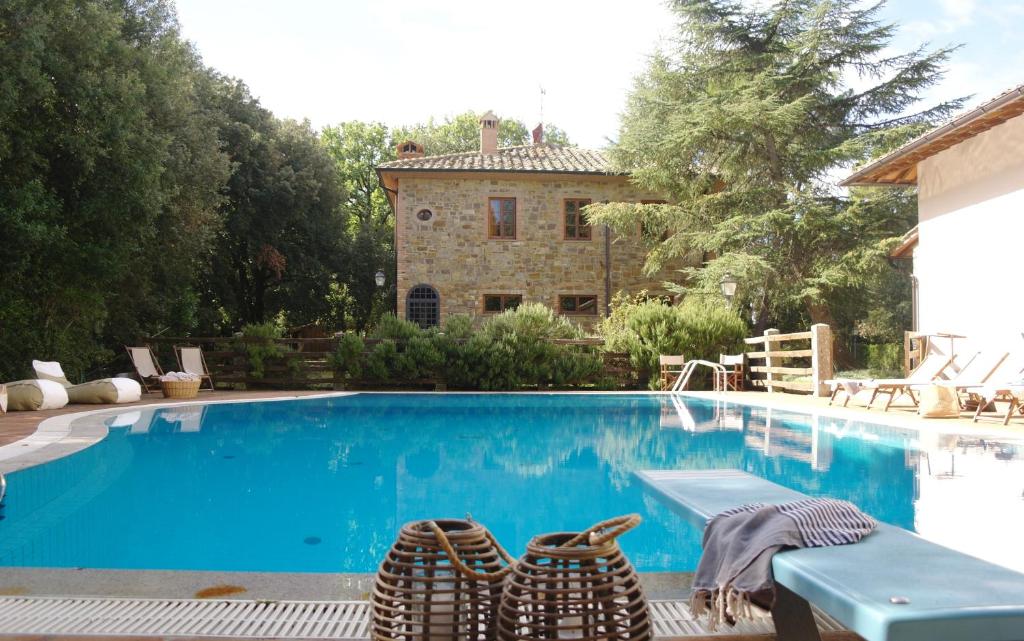 une piscine avec deux chaises et une maison dans l'établissement Villa Montignoso, à Castagno