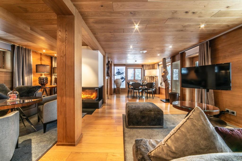 un salon avec une cheminée et une télévision dans l'établissement Le Strato, à Courchevel