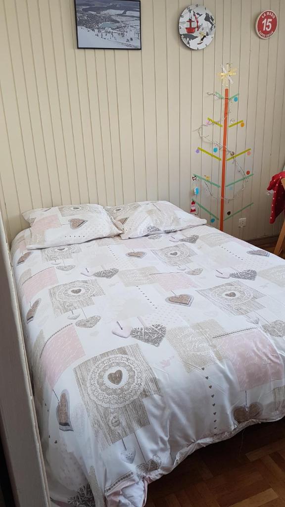 - un lit avec une couverture et un arbre de Noël dans l'établissement Studio-cabine au pied des pistes à Super Besse, à Super-Besse