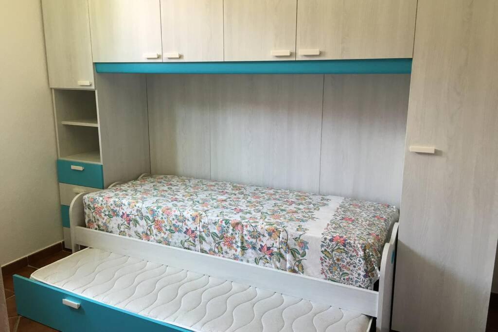 Ce petit lit se trouve dans une petite chambre dotée de lits superposés. dans l'établissement VILLAROSA Views, à Porto San Paolo