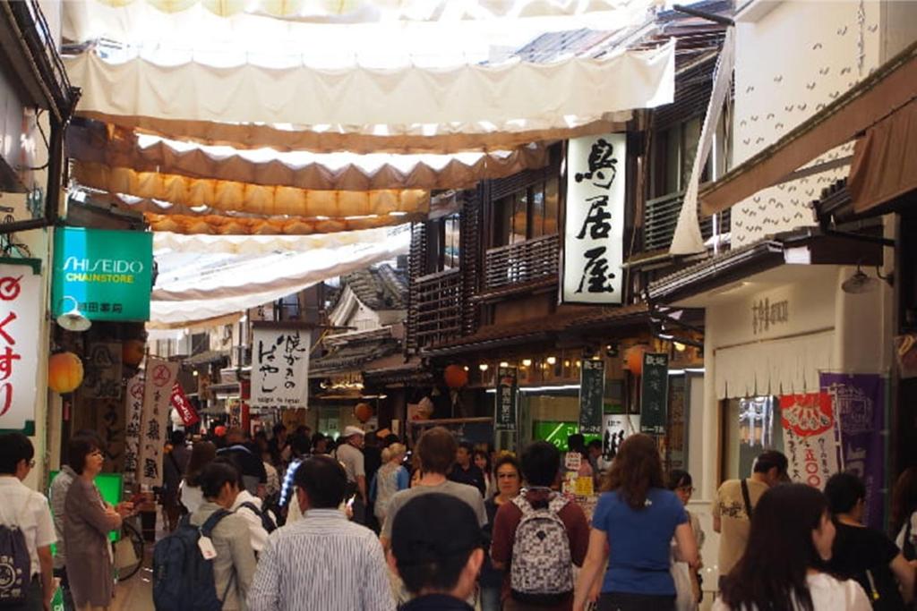Une foule de gens marchant dans une rue d'un marché dans l'établissement Miyajima Shiro, à Miyajima