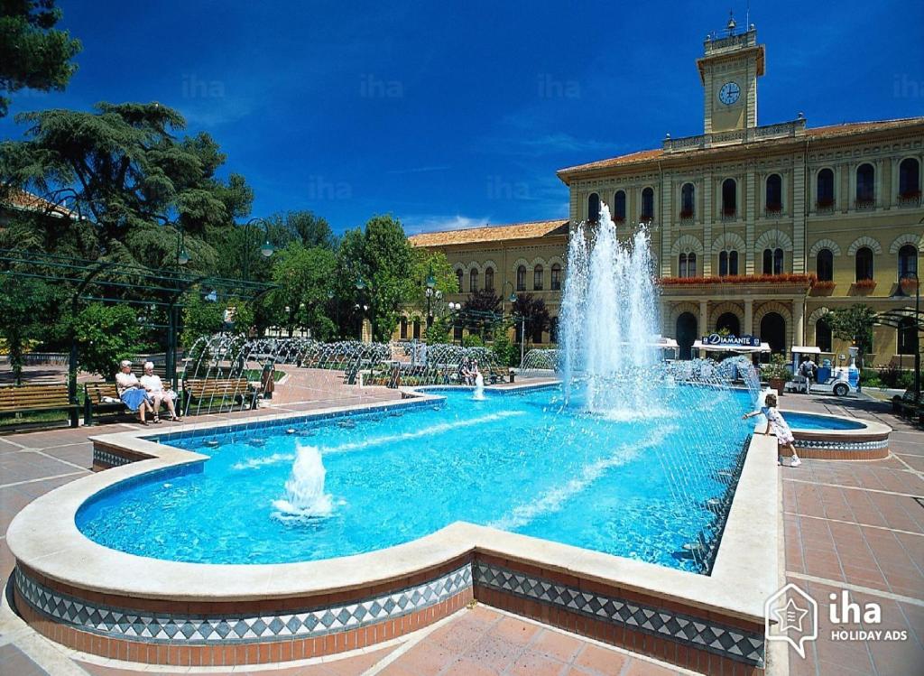 une fontaine devant un bâtiment avec une tour d'horloge dans l'établissement Hotel Principe, à Cattolica