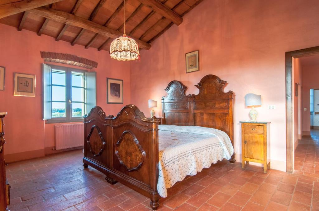 une chambre avec un grand lit en bois dans une pièce dans l'établissement Cottage Il Faldo, à Paciano