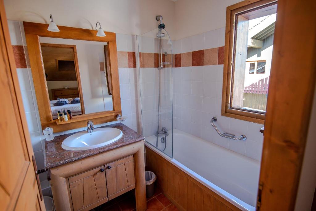 une salle de bain avec un lavabo, une baignoire et un miroir dans l'établissement Bel Appartement spacieux 65m2 Les Arcs 1950, à Arc 1950