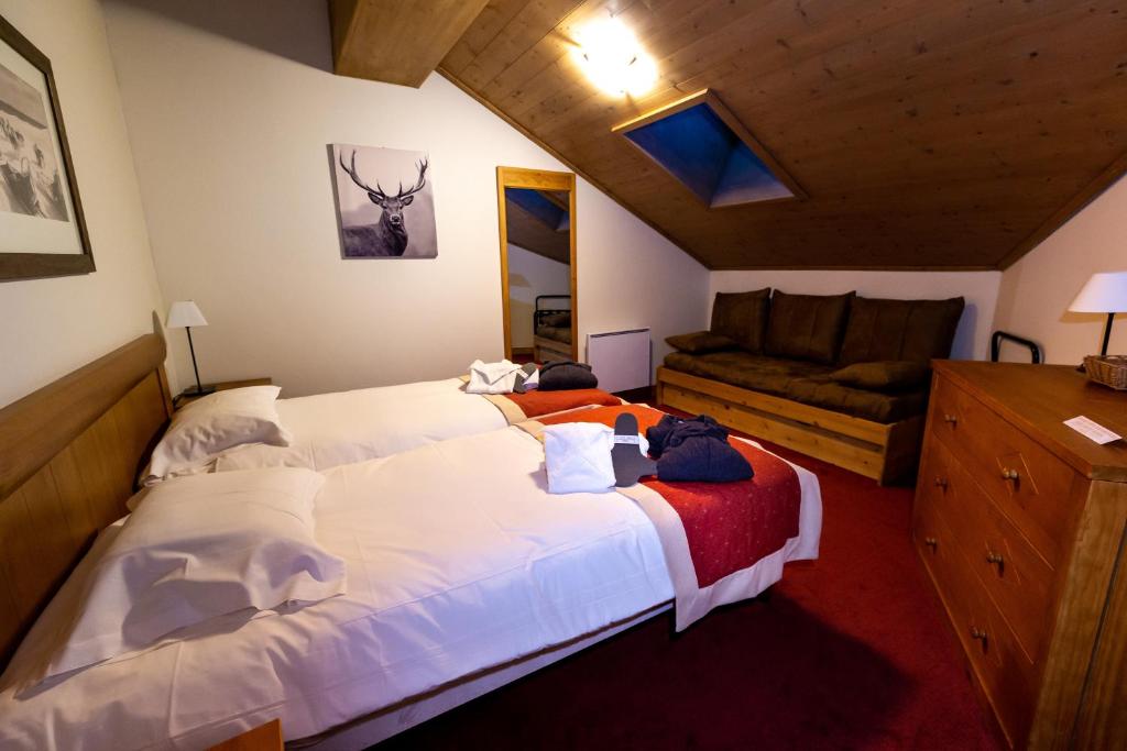 une chambre avec deux lits et un canapé dans l'établissement Bel Appartement spacieux 65m2 Les Arcs 1950, à Arc 1950