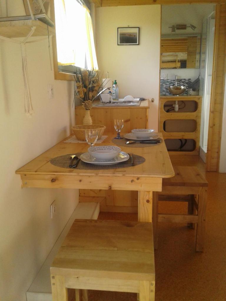 - une cuisine avec une table en bois et 2 verres dans l'établissement Tiny house sur la Presqu'île Sauvage, à Lanmodez 3 autres photos