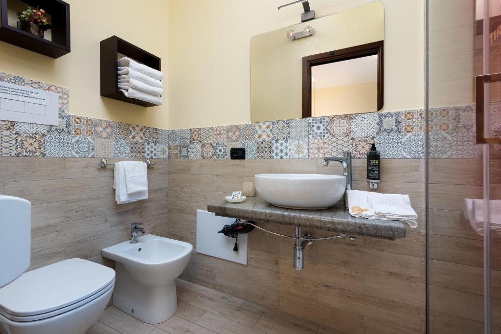 une salle de bain avec un lavabo, des toilettes et un miroir dans l'établissement Hotel Baia Di Venere, à San Vito Lo Capo 125 autres photos