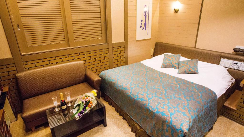 une chambre d'hôtel avec un lit et un banc à l'intérieur dans l'établissement Restay Hakodate(Adult Only), à Hakodate