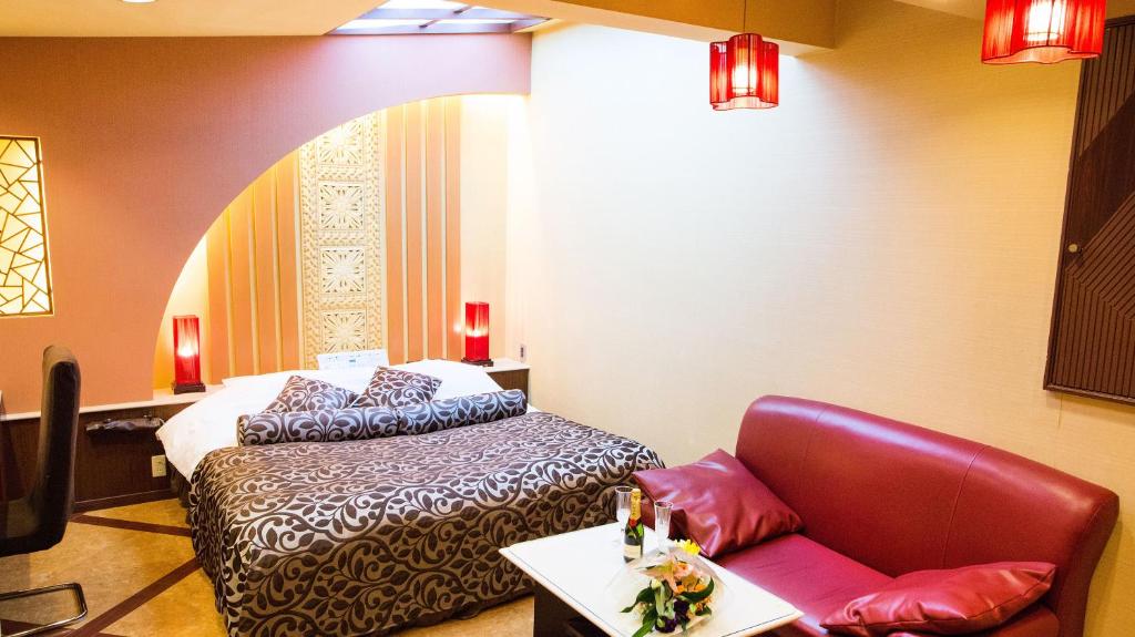 une chambre avec un lit, une chaise et une table dans l'établissement Restay Hakodate(Adult Only), à Hakodate