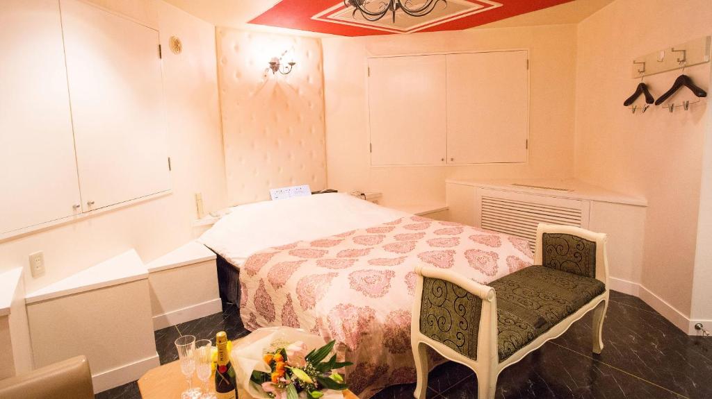une chambre avec un lit, une table et des chaises dans l'établissement Restay SaKuRa (Adult Only), à Hakodate