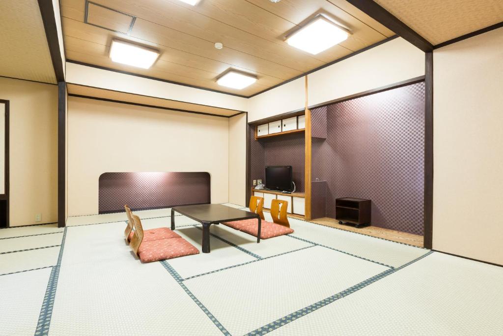 une pièce avec une table et deux chaises et une télévision dans l'établissement Ryokan Sanoya, à Kyoto