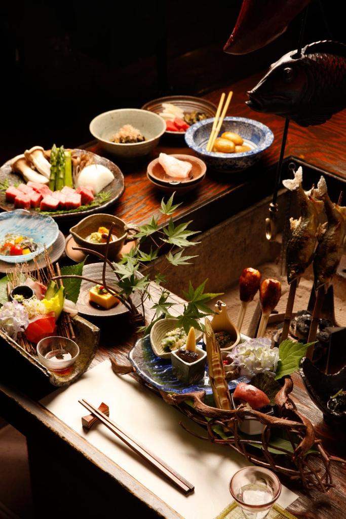 une table avec de nombreux plats et baguettes dans l'établissement Hidaji (Adult Only), à Takayama
