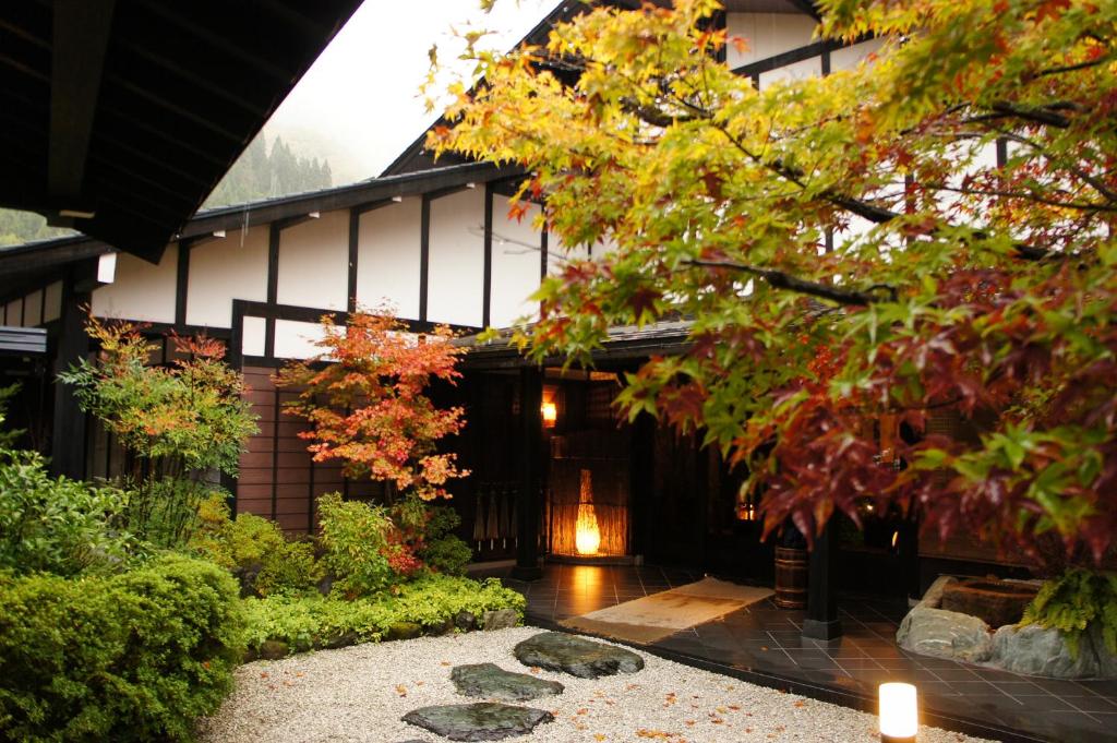 un bâtiment avec une cour ornée de rochers et d'arbres dans l'établissement Hidaji (Adult Only), à Takayama