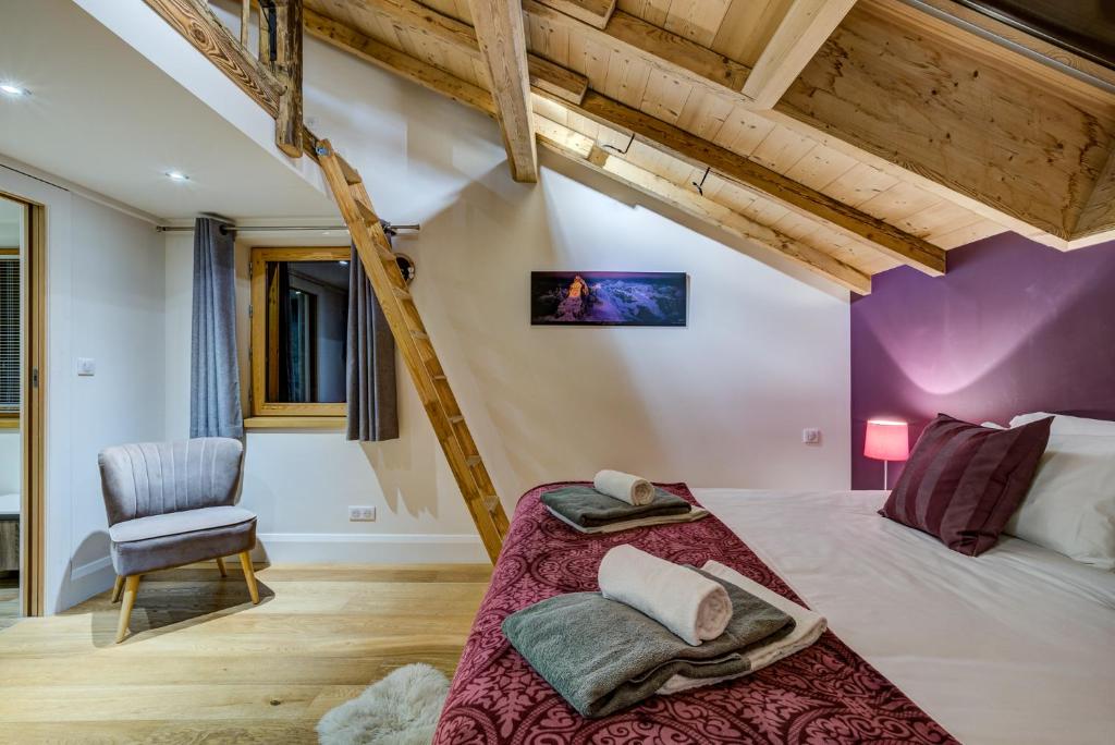 une chambre avec un grand lit et une chaise dans l'établissement Chalet Rubicon, aux Houches