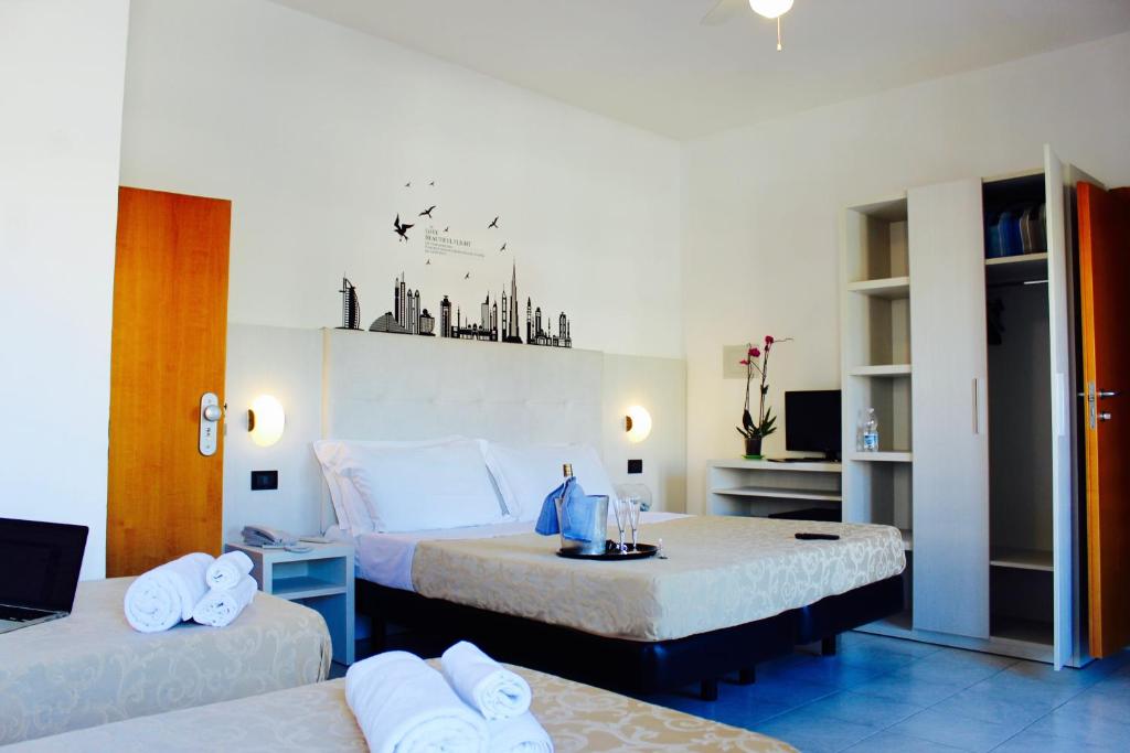une chambre d'hôtel avec deux lits et une table dans l'établissement Hotel Marina, à Riccione 61 autres photos