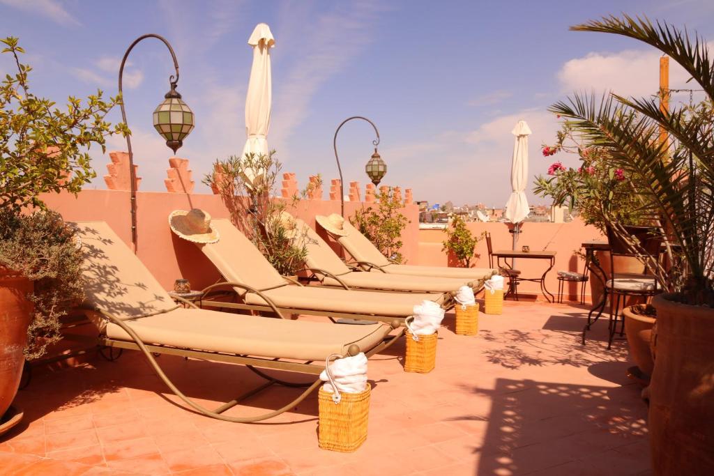 une rangée de chaises longues sur une terrasse dans l'établissement Dar Andamaure, à Marrakech