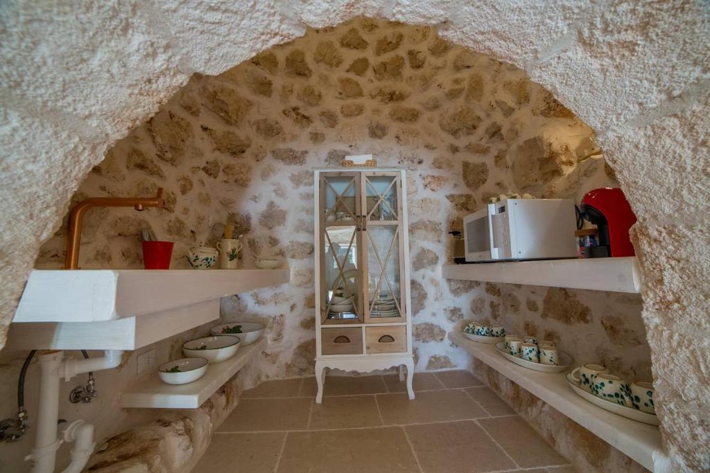 une cuisine avec deux lavabos et un mur en pierre dans l'établissement Tenuta Trullo Padronale-Private Pool Exclusive Villa Ostuni, à Ostuni
