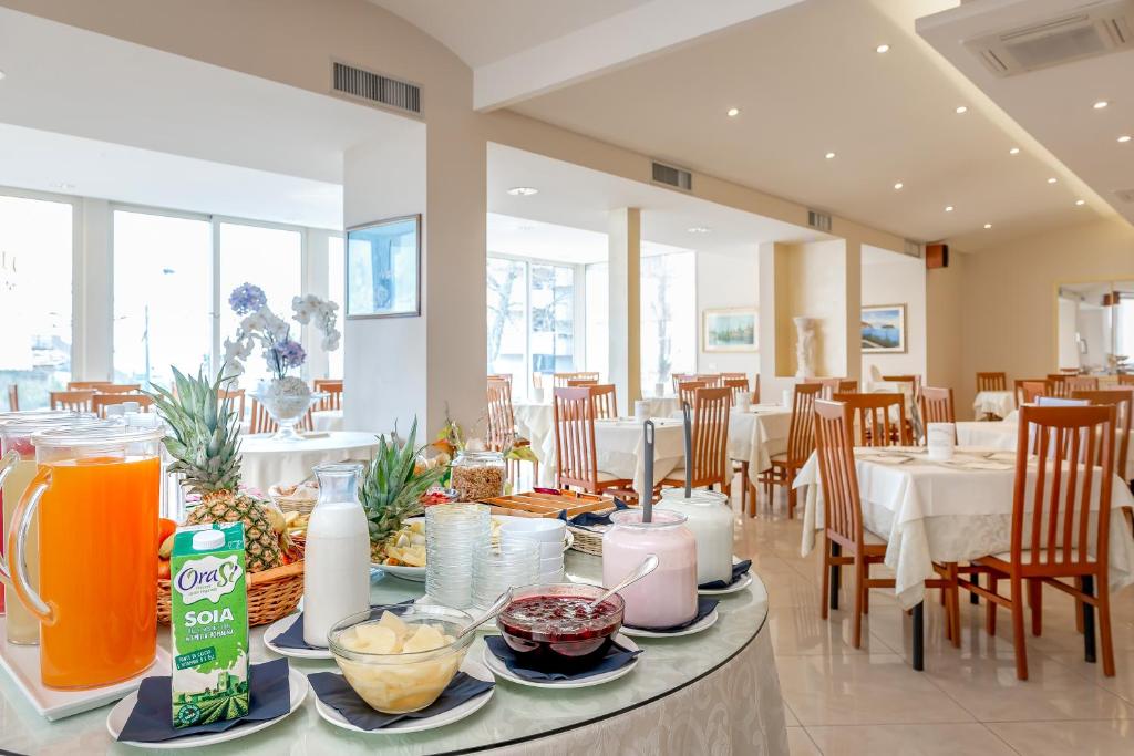 une salle à manger avec une table sur laquelle se trouve de la nourriture dans l'établissement Hotel Sole Mio, à Rimini