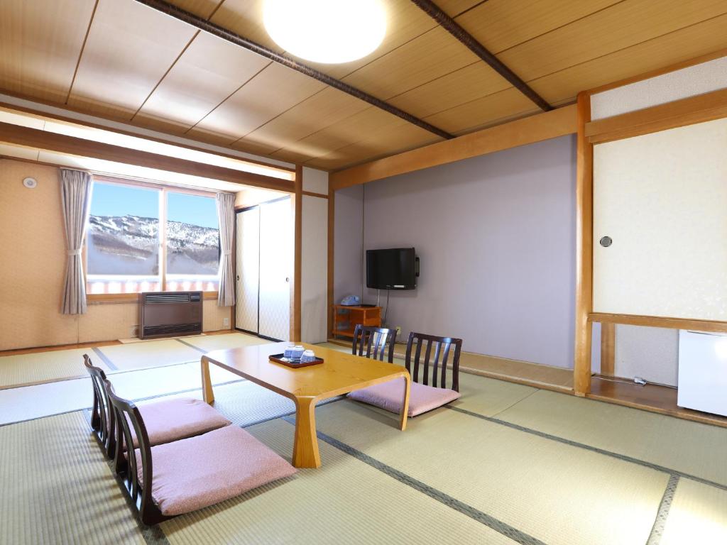 une salle de réunion avec une table, des chaises et un écran dans l'établissement Shiga Ichii Hotel, à Yamanouchi