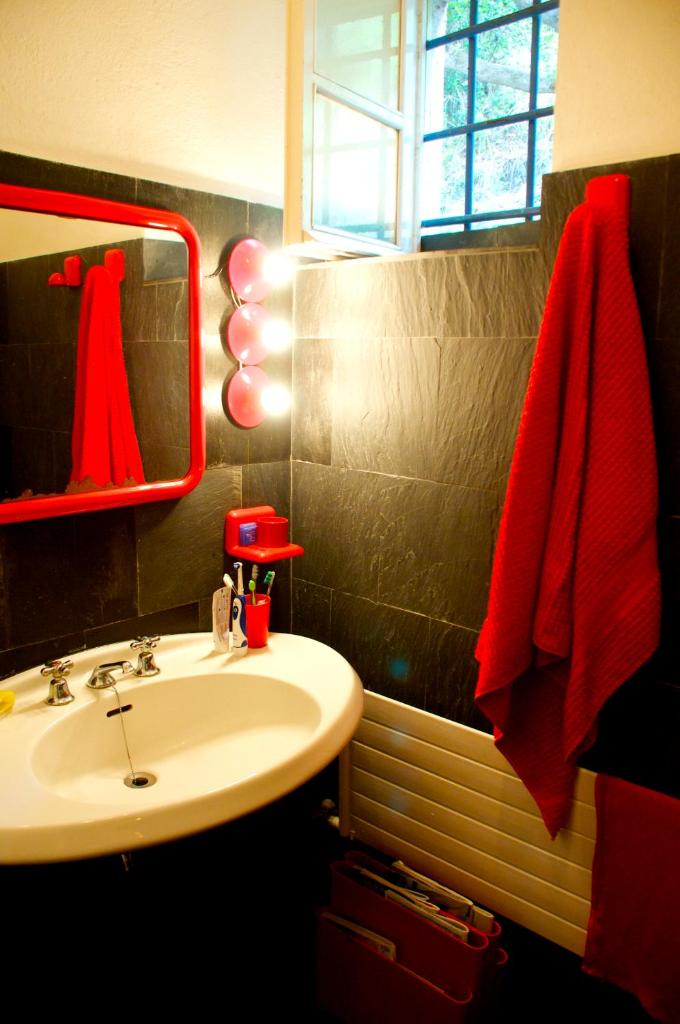 une salle de bain avec un lavabo et une serviette rouge dans l'établissement Maison de Charme Giulietta, à Bonassola