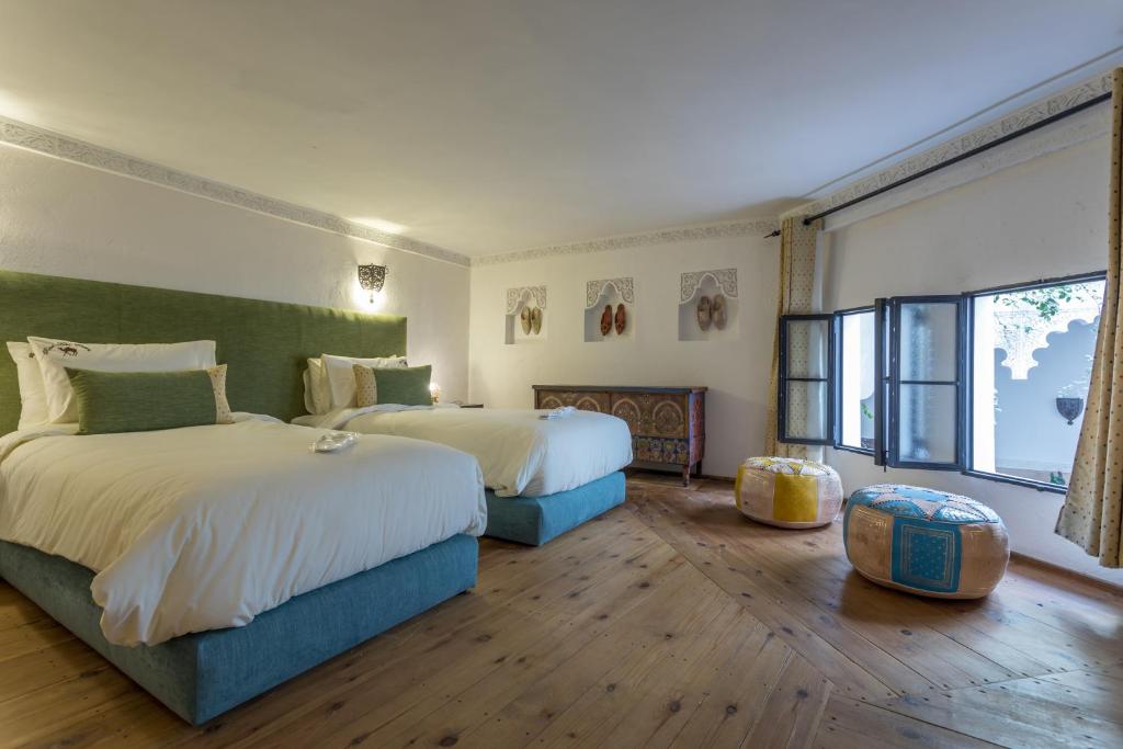 une chambre avec deux lits et une grande fenêtre dans l'établissement Riad Hart Essoura, à Marrakech